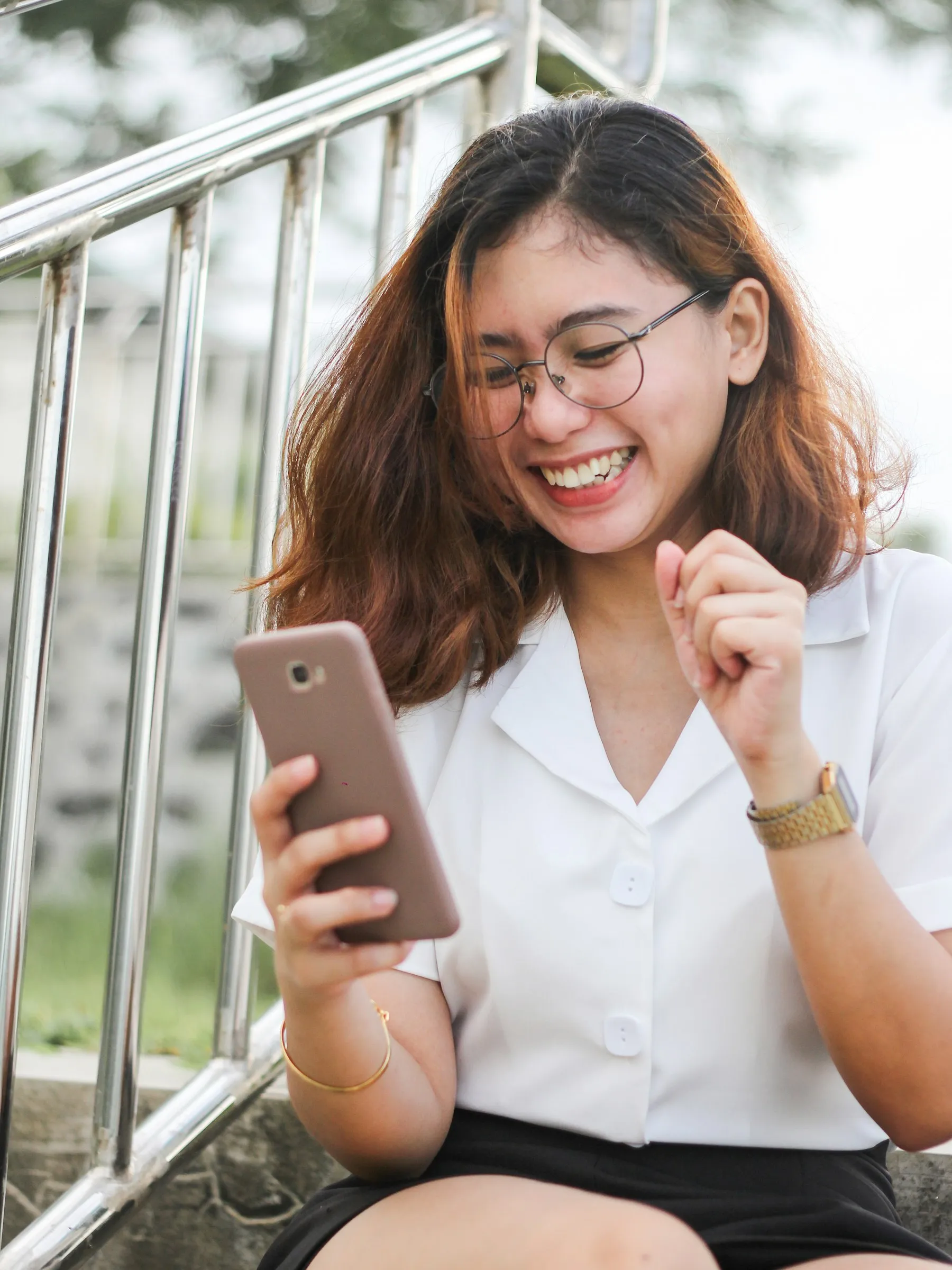 Pelanggan tersenyum saat membalas chat di HP